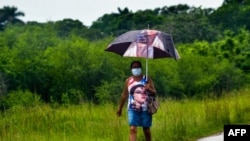 Una mujer se protege del contagio de coronavirus en Cuba con una mascarilla. (YAMIL LAGE / AFP)