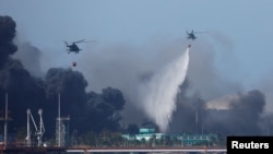 Helocópteros arrojan agua sobre las llamas en Matanzas, el 8 de agosto de 2022. (REUTERS/Alexandre Meneghini).