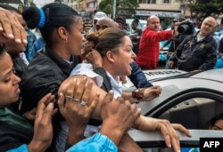 Una miembro de las Damas de Blanco es arrestada en una calle de La Habana por manifestarse pacíficamente.