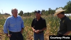 El gobernador de Missouri Jay Nixon (i) visita una granja del Estado afectada por la sequía y el calor.