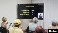 La gente observa los resultados de la votación en un centro de vacunación el 23 de junio de 2021. REUTERS / Alexandre Meneghini