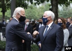 Un saludo entre Joe Biden (izq.) y el vicepresidente Mike Pence durante la ceremonia.AMR ALFIKY / POOL / AFP
