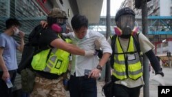 Paramédicos ayudan a un manifestante alcanzado por gas lacrimógeno durante una protesta en Causeway Bay, Hong Kong. (AP/Vincent Yu)