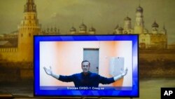 Aleksey Navalny en una pantalla de televisión cuando era enjuiciado en un tribunal de Moscú el 28 de enero de 2021. (AP Photo/Alexander Zemlianichenko).