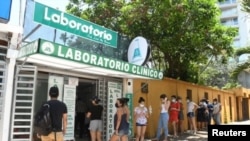 Una fila de personas espera en un centro de pruebas de COVID-19 en Santa Cruz, Bolivia, el 29 de diciembre de 2021.