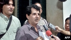 El disidente cubano Oswaldo Payá, del Movimiento Cristiano Liberación, habla con reporteros frente a la Asamblea Nacional en La Habana, el 10 de mayo de 2002.