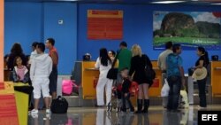 Varias personas chequean sus documentos para abordar un vuelo hacia Miami (EEUIU), en la Terminal 2 del aeropuerto José Martí de La Habana (Cuba).