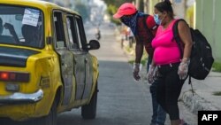 Una pareja habla con un taxista la mañana del lunes en una calle de La Habana (Yamil Lage/AFP).