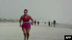 Mujer se ejercita en una playa de la Florida.