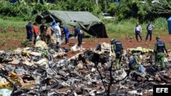 Personal cubano trabaja entre los escombros del avión accidentado en La Habana.