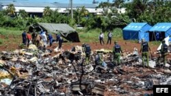 Personal cubano trabaja entre los escombros del avión accidentado en La Habana.