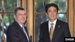 El primer ministro japojés, Shinzo Abe (d), da la bienvenida al presidente del Comité Olímpico Internacional (COI), Thomas Bach.