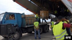 Trabajadores descargan en Santiago de Cuba un envío de ayuda humanitaria proveniente de Rusia. 