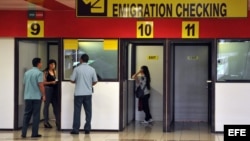 Dos mujeres chequean su pasaportes en las cabinas de emigración del aeropuerto Internacional José Martí en La Habana. Cuba.