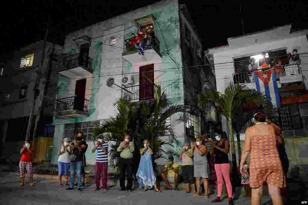 Vecinos de un barrio habanero aplauden el 30 de marzo a médicos y enfermeras que combaten el coronavirus en la capital de Cuba (Foto: Yamil Lage/AFP).