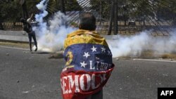 Un manifestante se enfrenta a los soldados de la Guardia Nacional durante las protestas en Caracas.