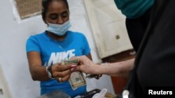 Un cliente paga en dólares en Caracas. (Reuters).