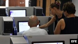 Varias personas se conectan a internet desde una sala de navegación en La Habana.