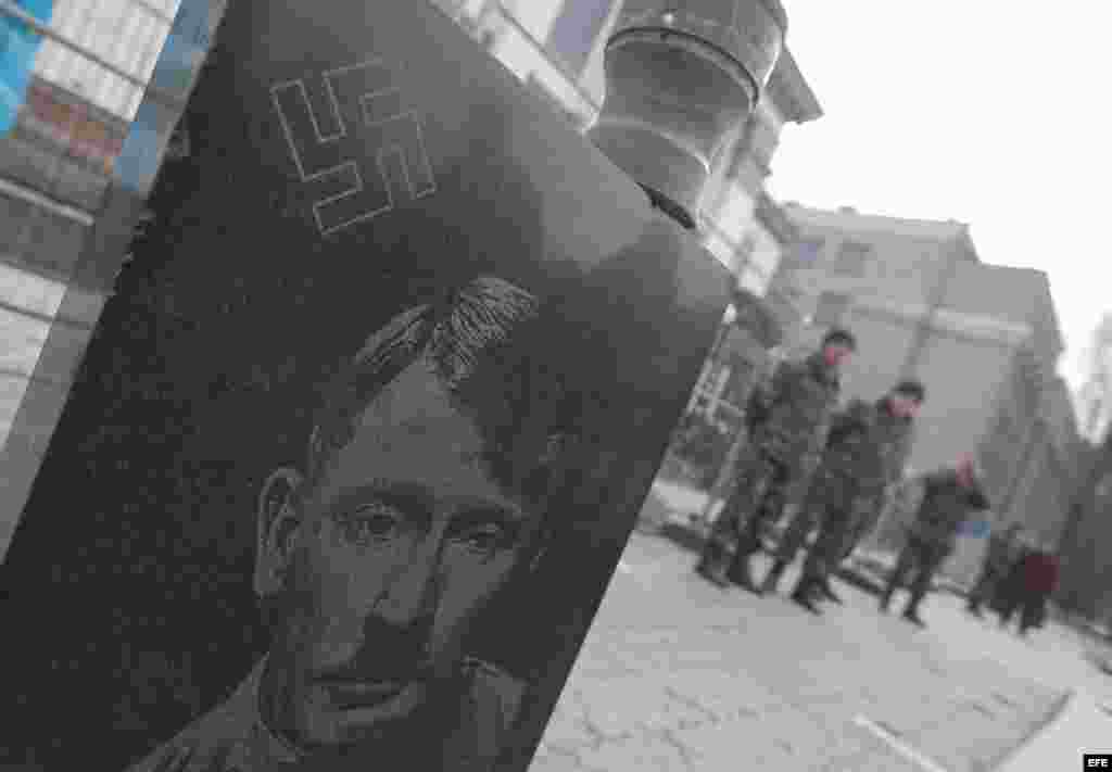 En la lápida hay grabados un insulto y una cruz gamada, y el rostro del presidente ruso, representado con un bigote y un corte de pelo como los de Hitler.