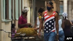 Un cubano camina por La Habana vistiendo una camiseta con la bandera estadounidense. (Yamil LAGE / AFP)