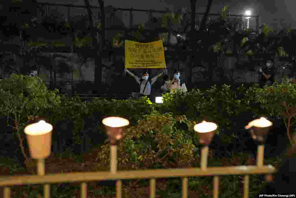 Un oficial de polic&#237;a sostiene una pancarta para advertir a la gente que enciende velas en las afueras de Victoria Park, en Hong Kong, para conmemorar los sucesos de Tiananmen, en su 32 aniversario. 
