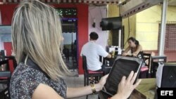 Una joven observa el menú en una tableta en un restaurante de La Habana.