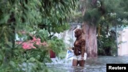 Una mujer camina en una calle inundada de Nassau, Bahamas, tras el efecto del huracán Dorian.
