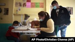 Una familia de migrantes hondureños se registra en la frontera mexicana para solicitar asilo en EEUU. (AP/Christian Chavez)
