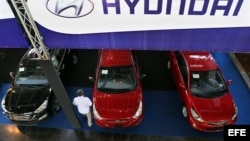 Un hombre observa varios de los autos surcoreanos en uno los pabellones de la Feria Internacional de La Habana, FIHAV 2013.