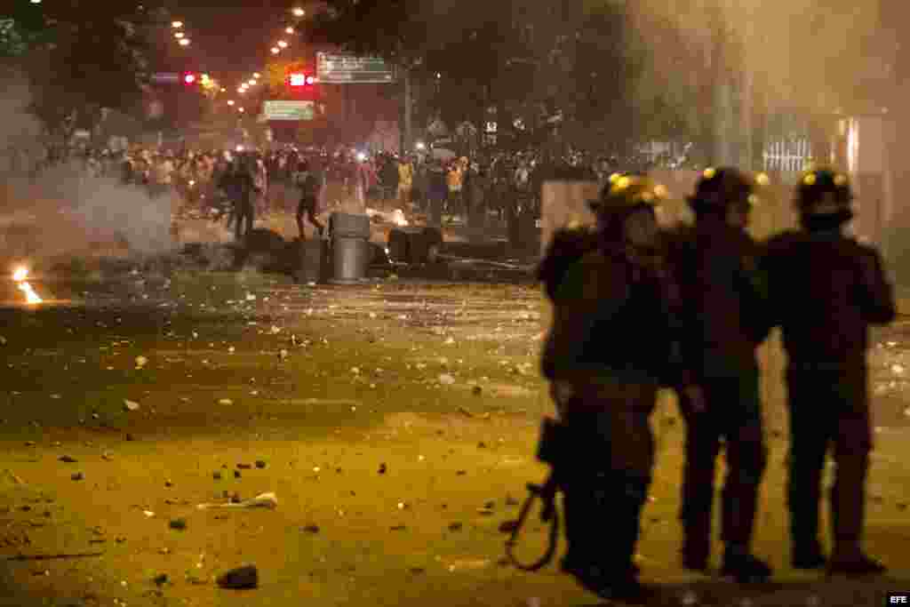 Miembros de la Guardia Nacional Bolivariana (GNB) enfrentan a protestantes hoy, viernes 14 de febrero de 2014.