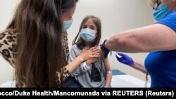 Una niña de 9 años de edad recibe una vacuna Pfizer contra el coronavirus durante un ensayo clínico en Carolina del Norte, EE. UU., en abril de 2021. Foto: Shawn Rocco/Duke Health/Mancomunada via REUTERS.