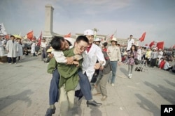 Un socorrista ayuda a un estudiante desmayado en su tercer día del huelga de hambre en la Plaza de Tiananmen, China el 16 de mayo de 1989. AP Photo/Sadayuki Mikami, File