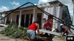 Ciudadanos cargan tejas para reparar el techo de sus casas en el pueblo de Los Palacios, provincia de Pinar del Río.