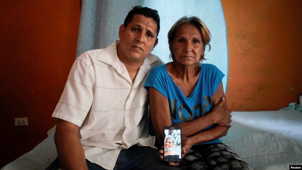 Alberto Betancourt y su madre Mayra Pérez posan con una foto de su hermana Daylin Betancourt, detenida por la policía durante una protesta, en La Habana, Cuba, el 19 de julio de 2021. Fotografía tomada el 19 de julio de 2021. REUTERS / Alexandre Meneghini