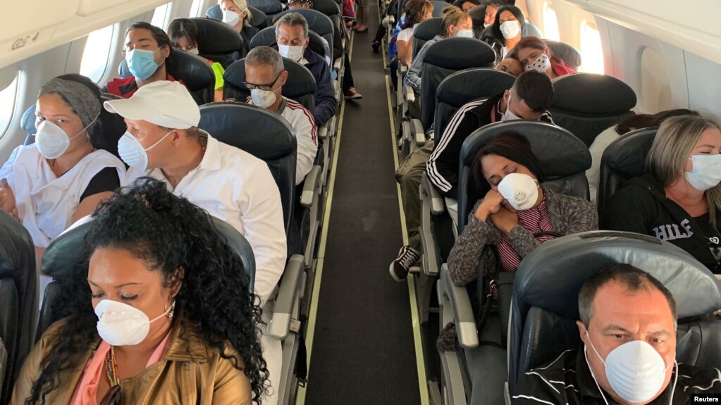 Personas en un vuelo de Caracas a La Habana se protegen con máscaras por temor al contagio con el coronavirus. REUTERS/Carlos Jasso