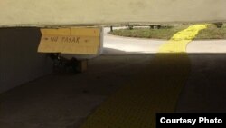 Un cartel advierte "No pasar" a la obra "Camino Limón", por el deterioro de sus piezas.