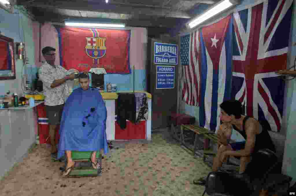 Banderas de EE UU, Reino Unido y Cuba en una barbería de La Habana.