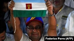 Sergio Garrido, gobernador electo de Barinas, celebra con la bandera del estado. (AFP/Federico Parra).