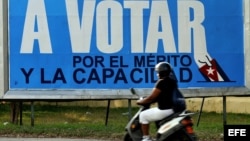 Una mujer pasa frente a un cartel alusivo a las elecciones municipales en Cuba. (Archivo)