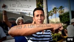 El cubano Alexander Otero muestra un tatuaje que dice "No a los Castros" durante una vigilia realizada hoy, miércoles 27 de julio 2016, frente al Restaurante Versailles en Miami, Florida.