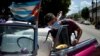 Un cuentapropista desinfecta su auto en La Habana para evitar la transmisión del coronavirus. (YAMIL LAGE / AFP)