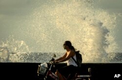 Una mujer se traslada en bicicleta por el Malecón habanero. (AP/Ramon Espinosa)