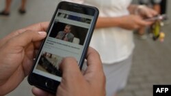 Cubanos usan sus teléfonos celulares para conectarse a internet.