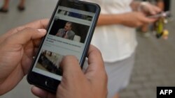 Cubanos usan sus teléfonos celulares para conectarse a internet. (YAMIL LAGE / AFP)