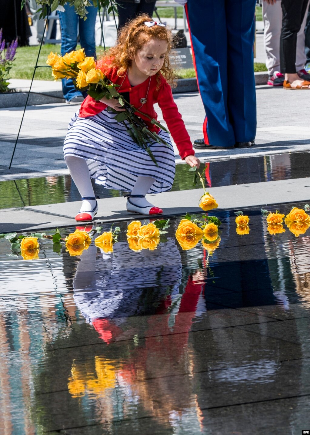 Una niña deposita flores en el Monumento a los Héroes Caídos, en Boston, Massachusetts.