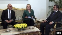 El presidente egipcio, Mohamed Morsi (der), se reúne con la secretaria de Estado de los Estados Unidos, Hillary Clinton (c), y el canciller egipcio, Mohamed Kamel Amr (izq).