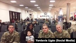 El boxeador cubano Yordenis Ugás, campeón del mundo, posa con su hijo y soldados de Estados Unidos.
