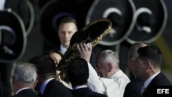 El papa Francisco (i) saluda a un grupo de mariachis a su llegada a México.