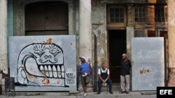 Tres hombres conversan a la entrada de un edificio en reparación en La Habana, Cuba