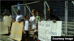Opositores cubanos reclaman frente a la sede de ACNUR en Trinidad y Tobago.